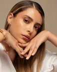 Woman wearing a white shirt and beige pants with a neutral background