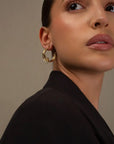 Claudette gold hoop earrings by PIERETTI in 18K gold plating, polished hoop design detail