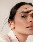 Noele gold wave hoop earrings by PIERETTI, polished 18K gold-plated wave design detail