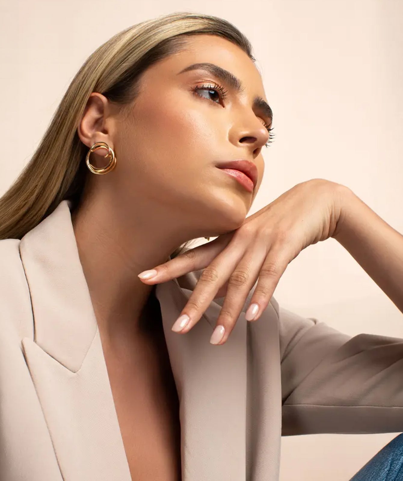 Cher gold earrings by PIERETTI worn on ear, elegant gold-plated earrings for everyday styling