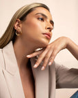 Cher gold earrings by PIERETTI worn on ear, elegant gold-plated earrings for everyday styling