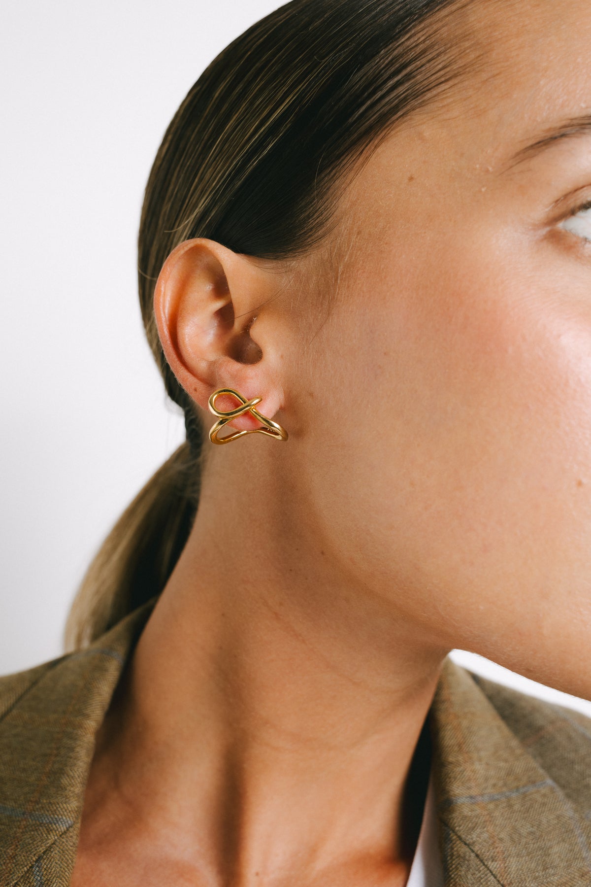 Model wearing Flor Huggie Earrings in Gold Plate by Pieretti