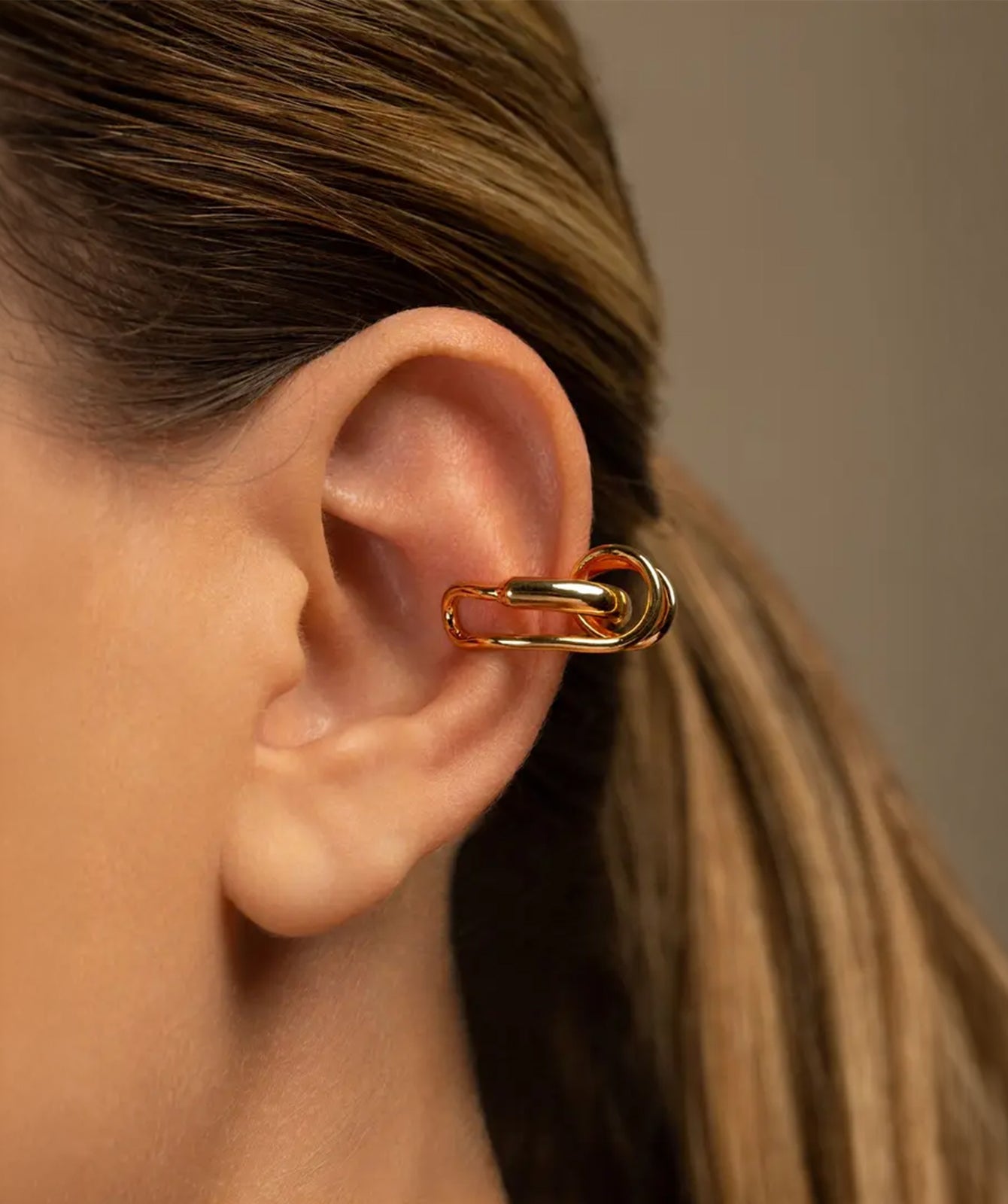Clau gold ear cuff by PIERETTI worn on ear, twisted ear cuff no piercing