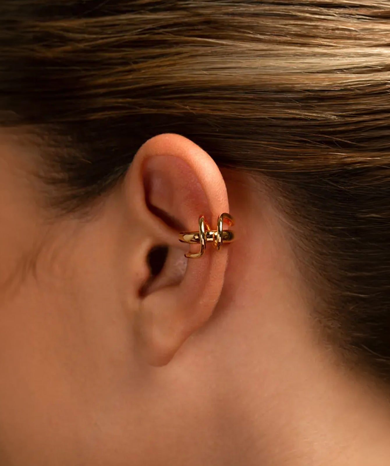 Clau twisted gold ear cuff by PIERETTI, polished sculptural design detail