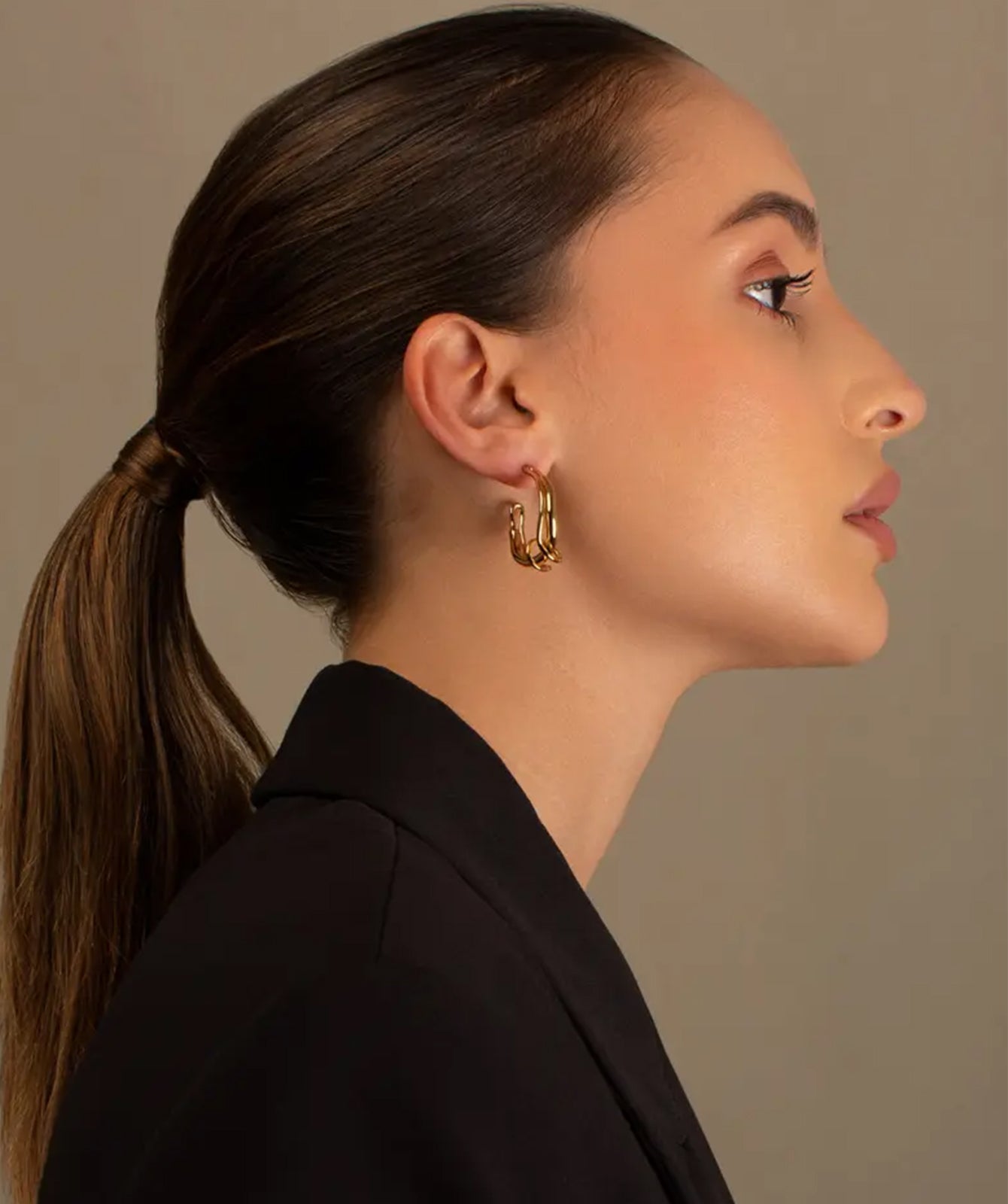 Claudette gold hoop earrings by PIERETTI worn on ear, medium gold hoops for everyday styling, available worldwide