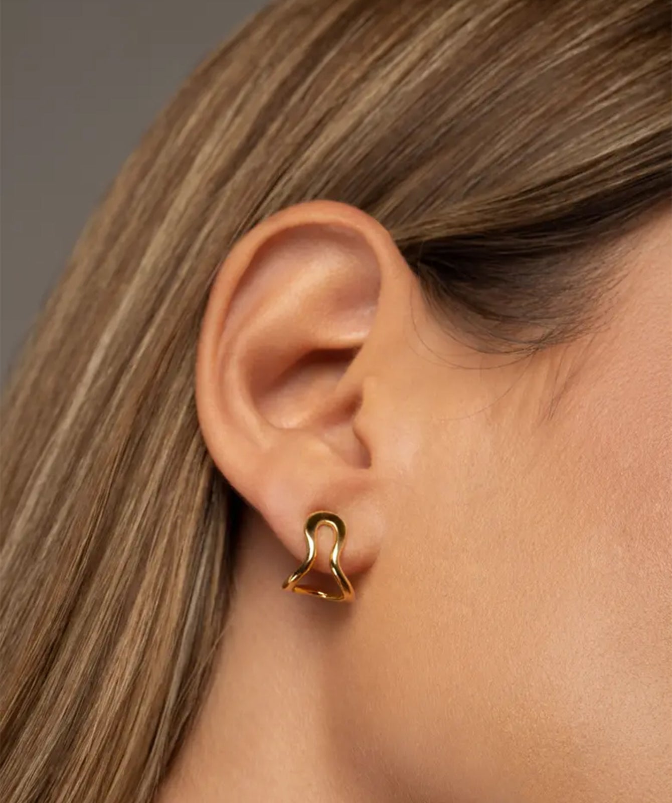 Conchi gold huggie earrings by PIERETTI, polished 18K gold-plated hoop design detail