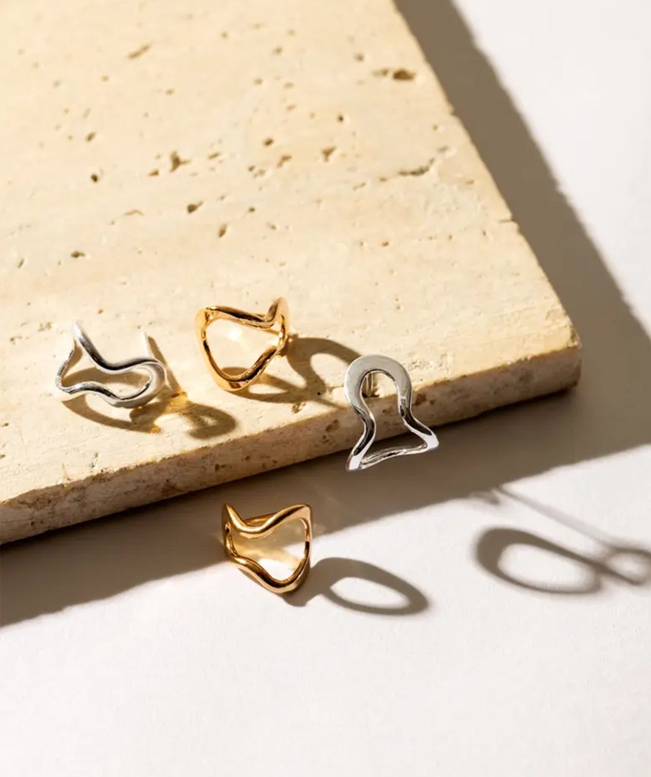 Conchi gold huggie earrings by PIERETTI styled with modern look, elegant small gold hoops