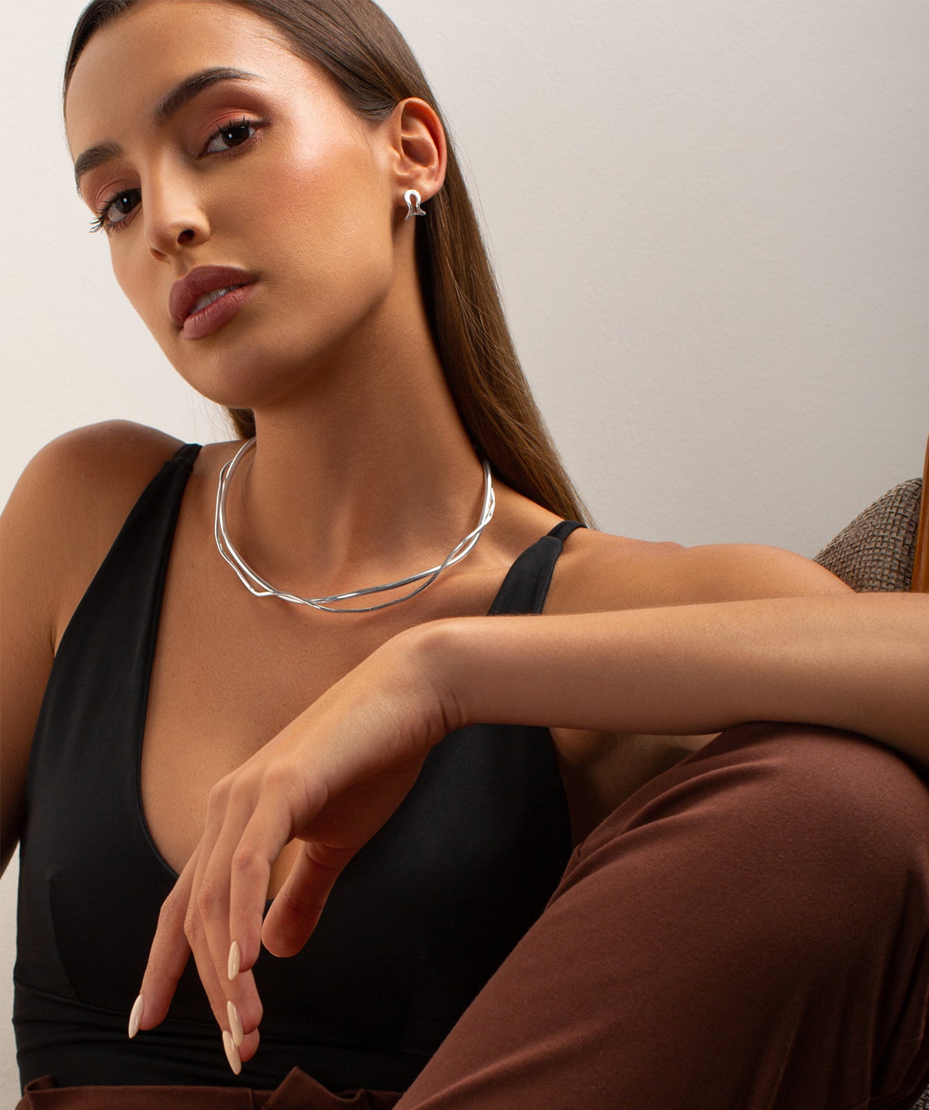 Conchi silver huggie earrings by PIERETTI worn on ear, small silver hoops for everyday styling