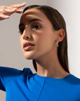Noele large silver hoop earrings by PIERETTI worn on ear, sculptural wave hoops for modern styling