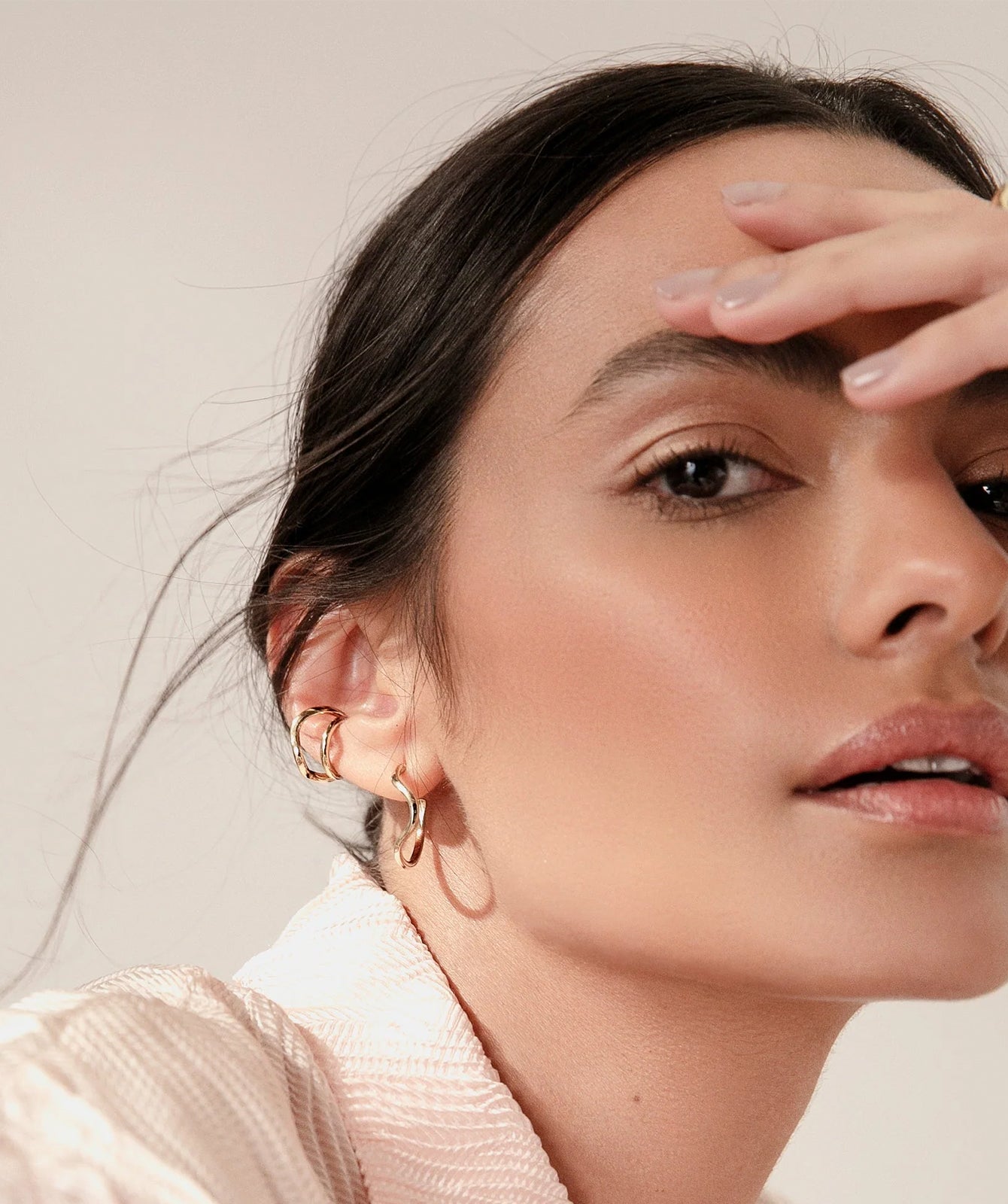 Noele gold wave hoop earrings by PIERETTI, polished 18K gold-plated wave design detail