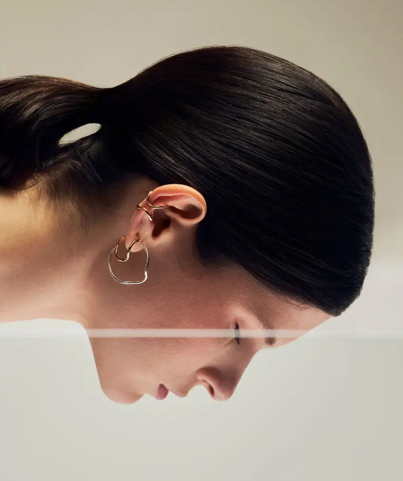 Noele gold wave hoop earrings by PIERETTI, polished 18K gold-plated sculptural design detail